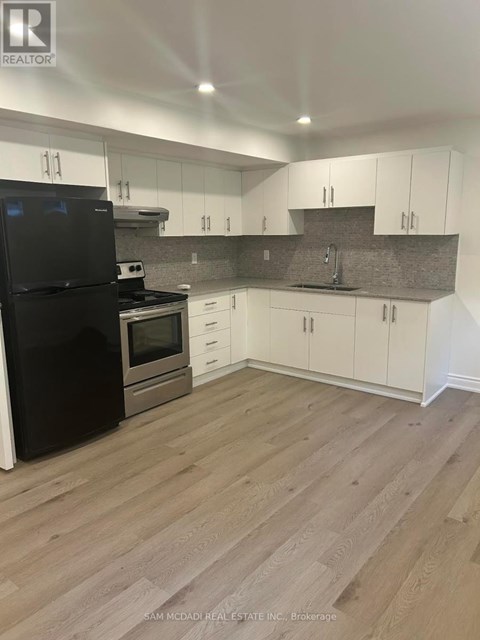 A kitchen with black appliances and white cabinets.