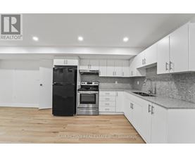 A kitchen with black appliances and white cabinets.