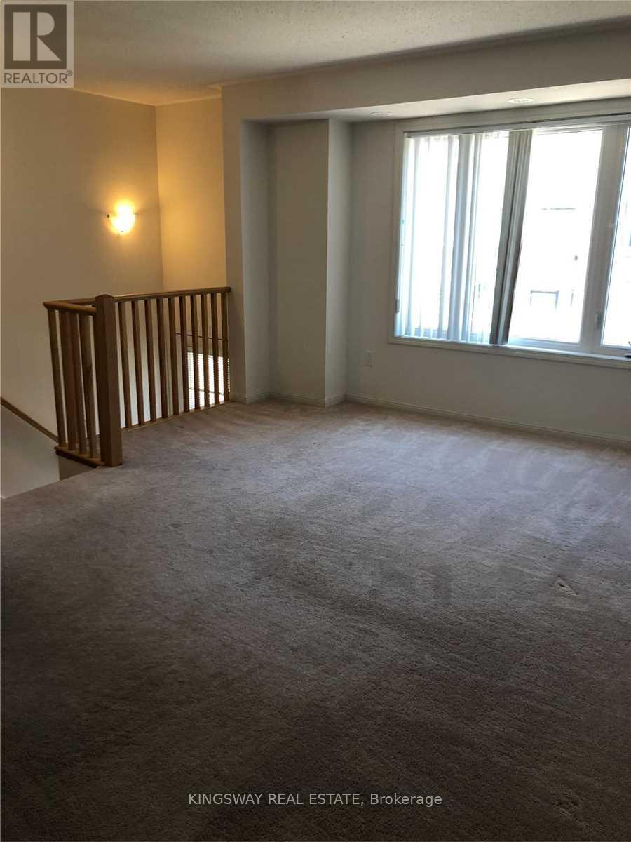 A room with a carpeted floor and a window with blinds.
