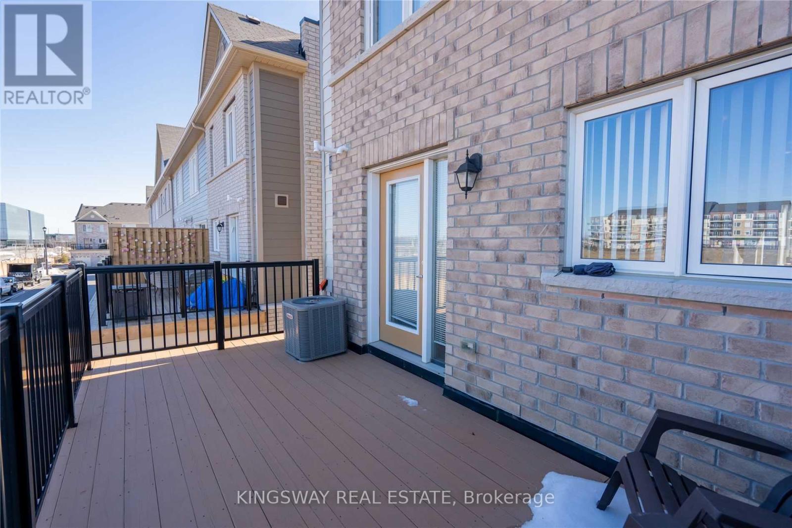 A real estate photo of a brick building with a balcony.