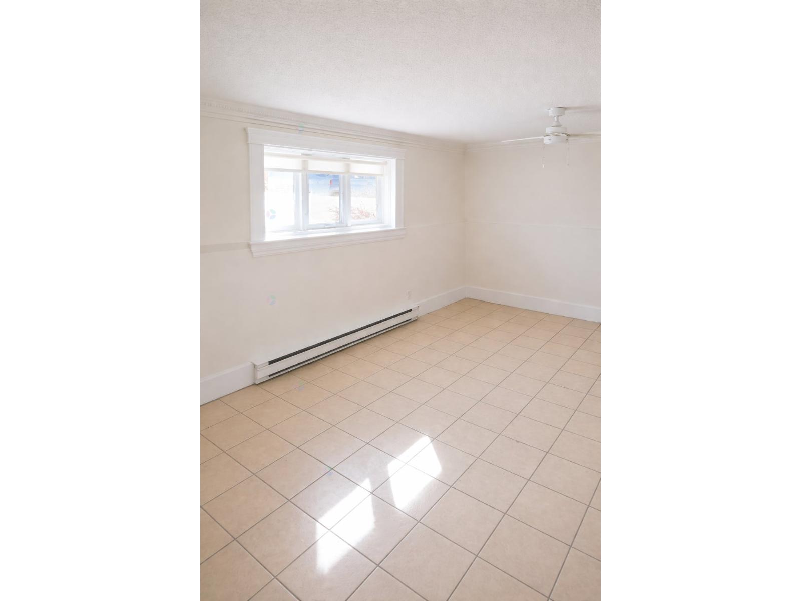 A room with a window and a radiator on the wall.
