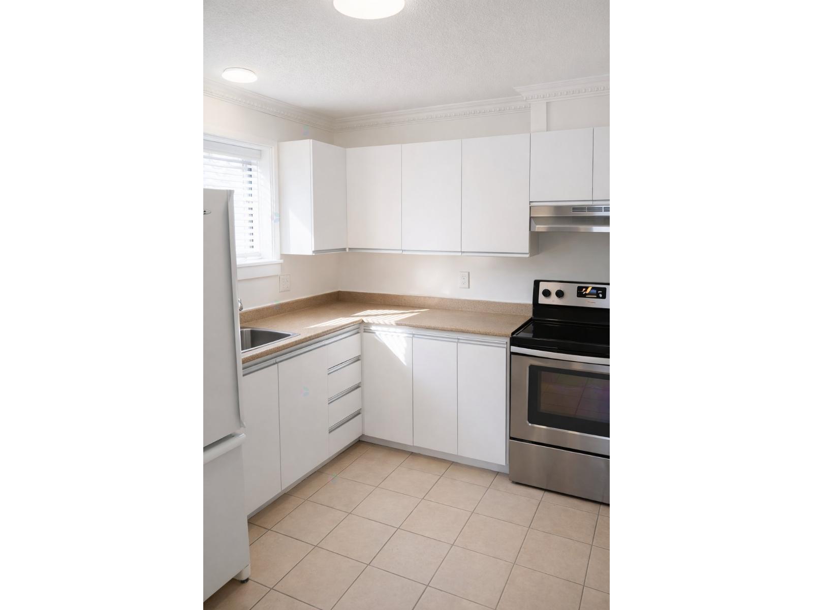 A kitchen with white cabinets and a stainless steel oven.