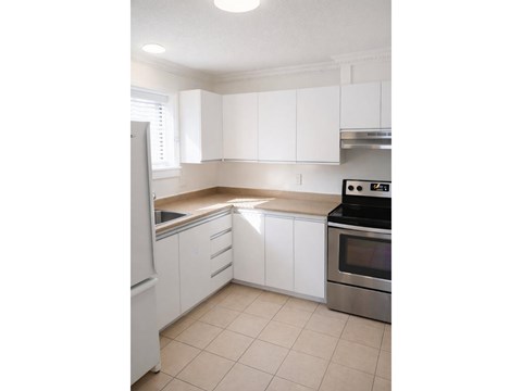 A kitchen with white cabinets and a stainless steel oven.