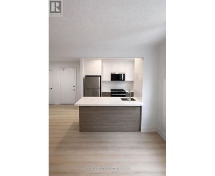 A modern kitchen with a wooden island and stainless steel appliances.