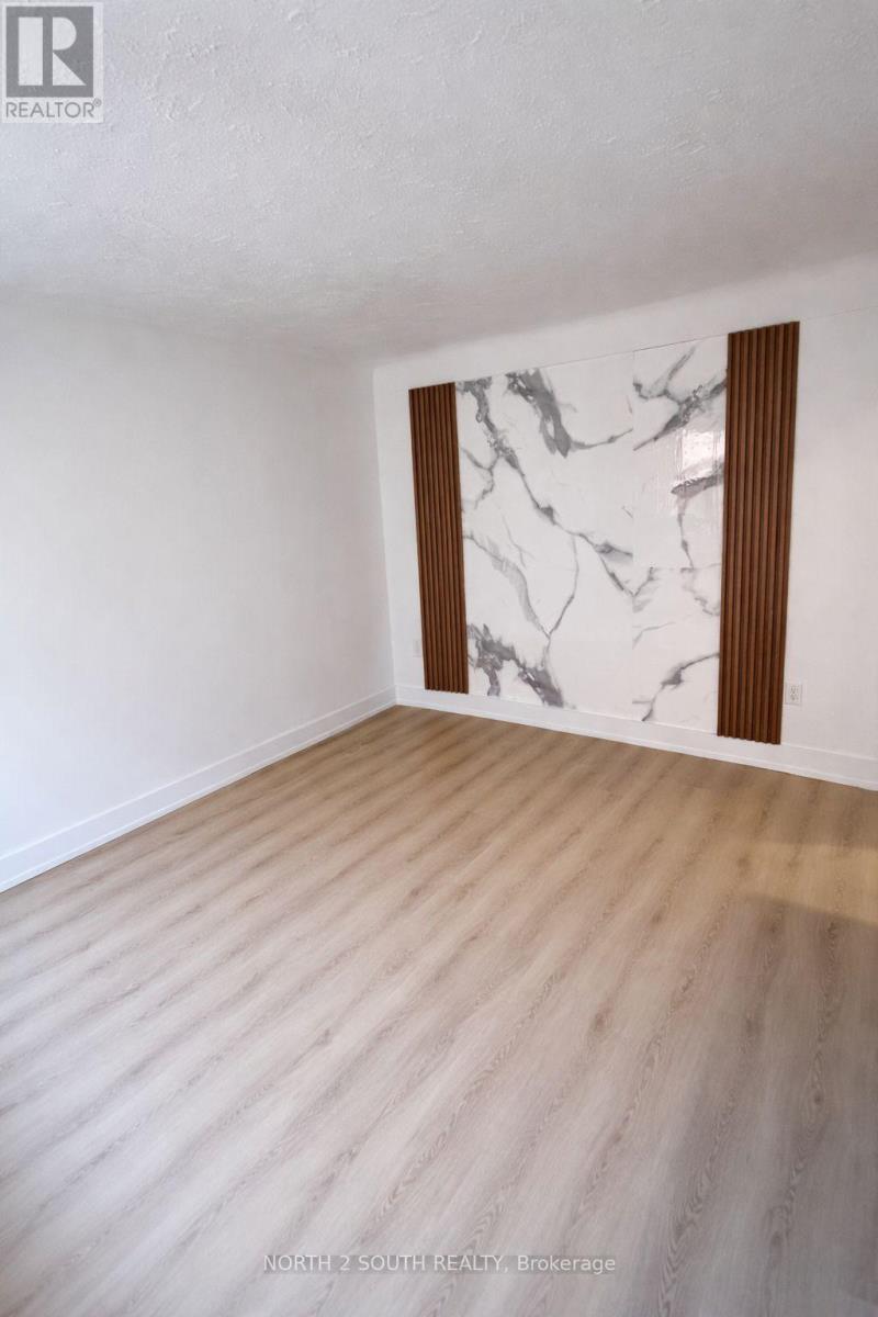 A room with a marble wall and wooden flooring.