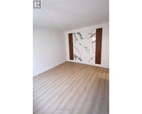 A room with a marble wall and wooden flooring.