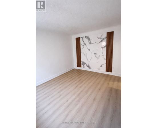A room with a marble wall and wooden flooring.