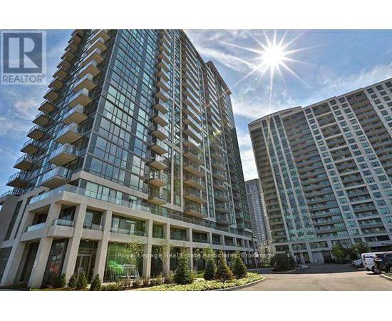A modern multi-story building with a glass facade and a sunny sky above.
