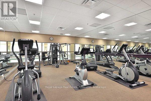 A gym with a variety of exercise equipment including treadmills, stationary bikes, and elliptical machines.