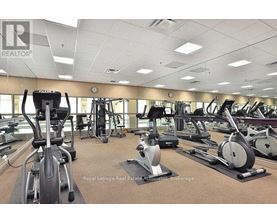 A gym with a variety of exercise equipment including treadmills, stationary bikes, and elliptical machines.