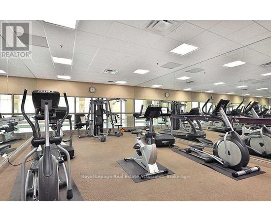 A gym with a variety of exercise equipment including treadmills, stationary bikes, and elliptical machines.