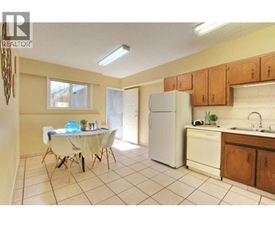 A kitchen with a table and chairs in the middle of the room.