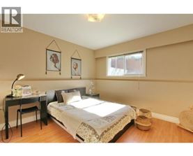 A bedroom with a bed, desk, and chair.