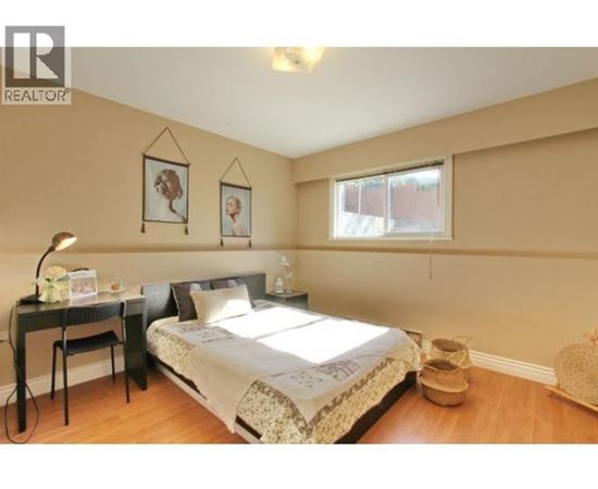 A bedroom with a bed, desk, and chair.