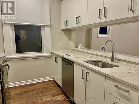 A white kitchen with a sink and cabinets.