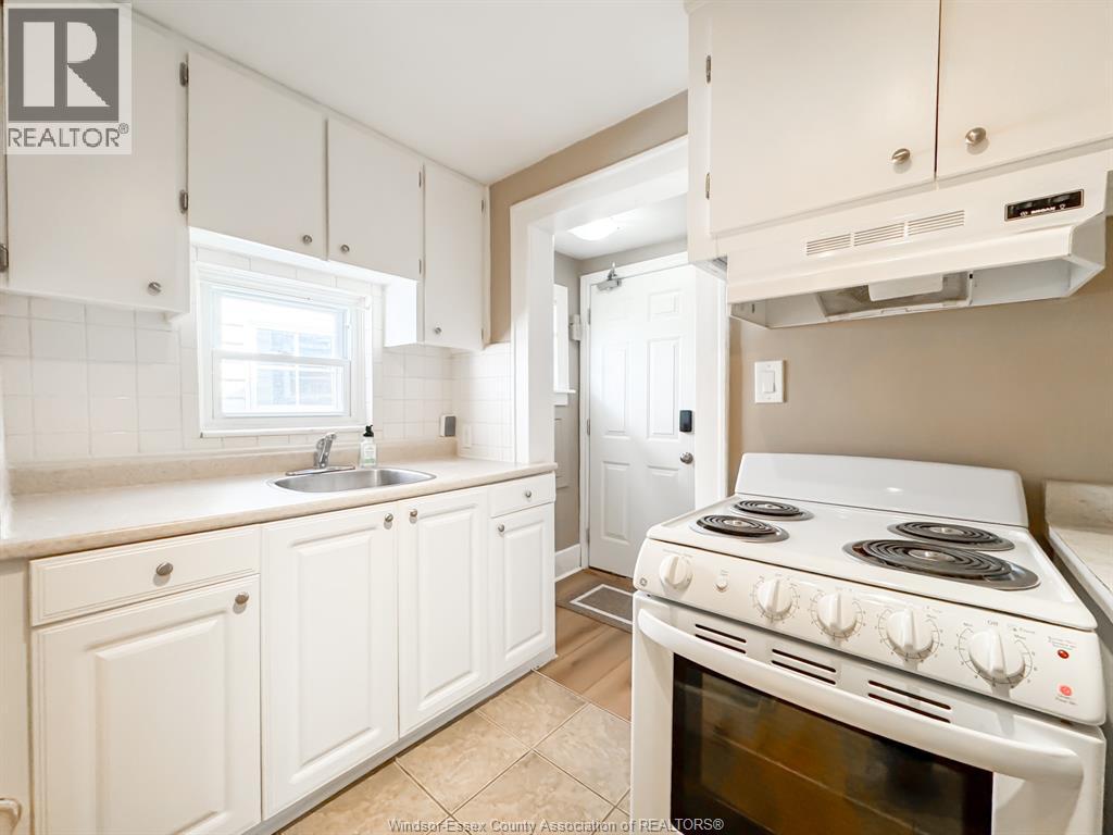 A kitchen with white cabinets and a white stove.