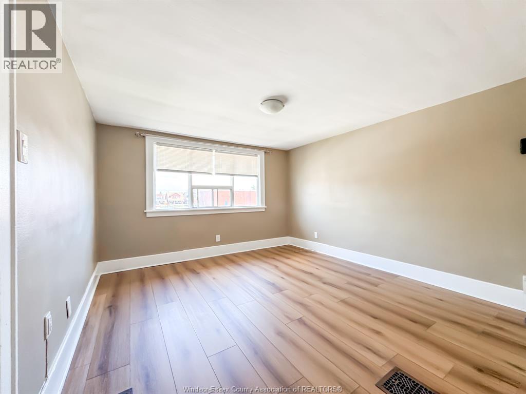 A room with wooden flooring and a window.