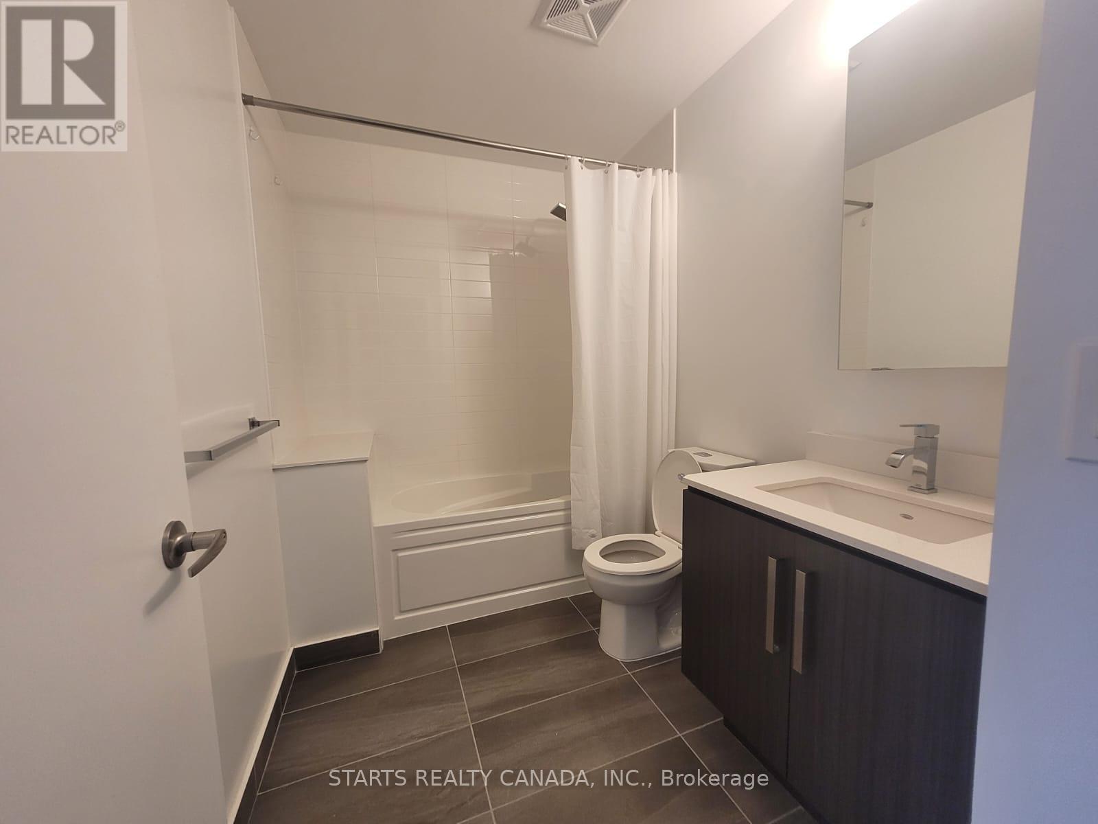 A bathroom with a toilet, sink, and bathtub.