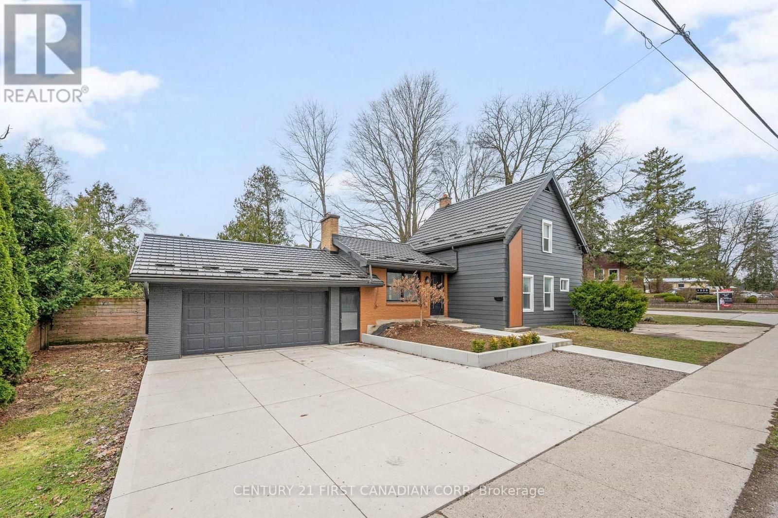 A house with a grey roof and a brown garage door is for sale.