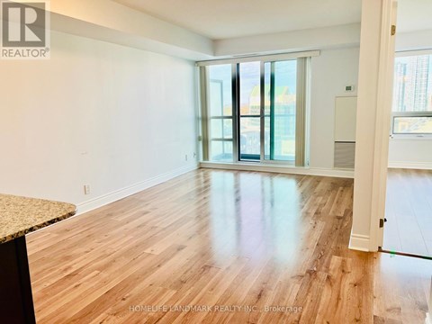 A room with wooden flooring and a sliding glass door.