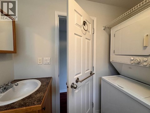 A bathroom with a sink, toilet, and a door.