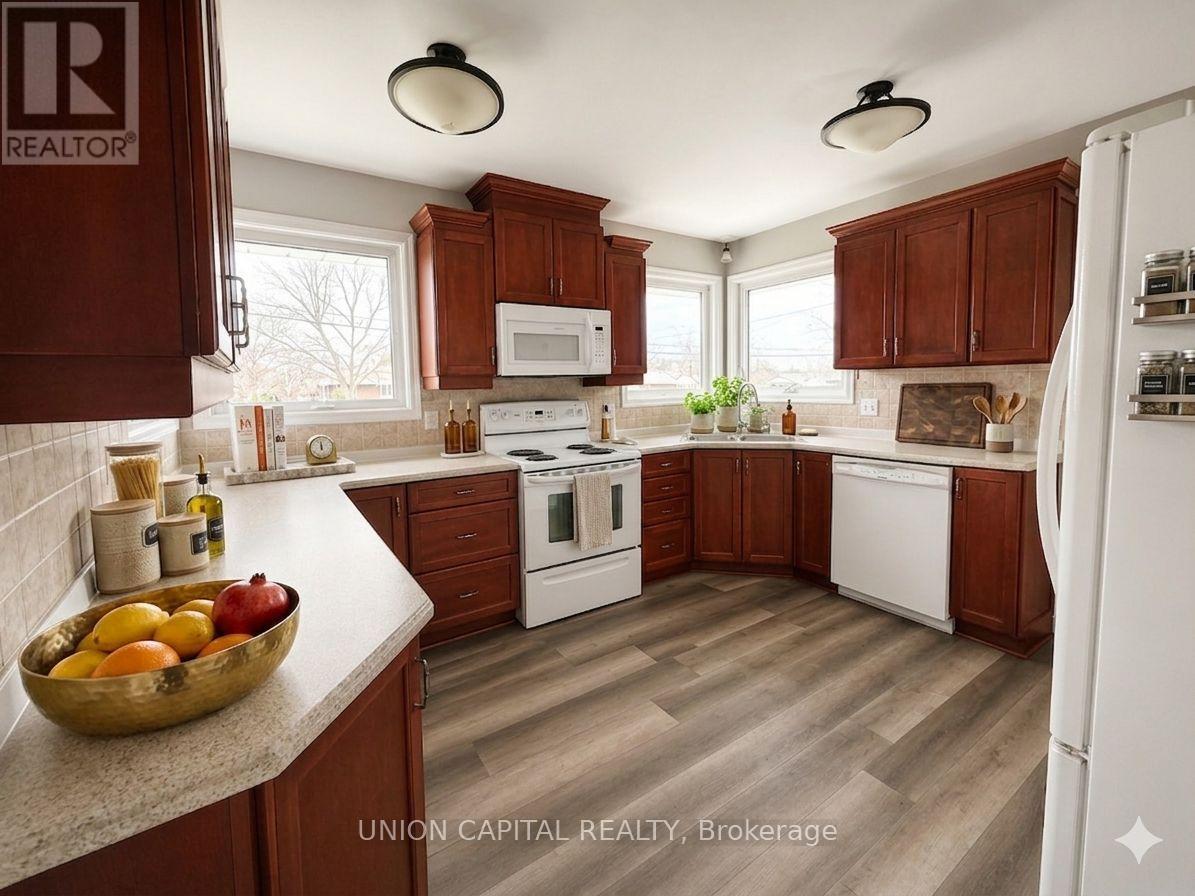 A kitchen with brown cabinets and a bowl of fruit on the counter.