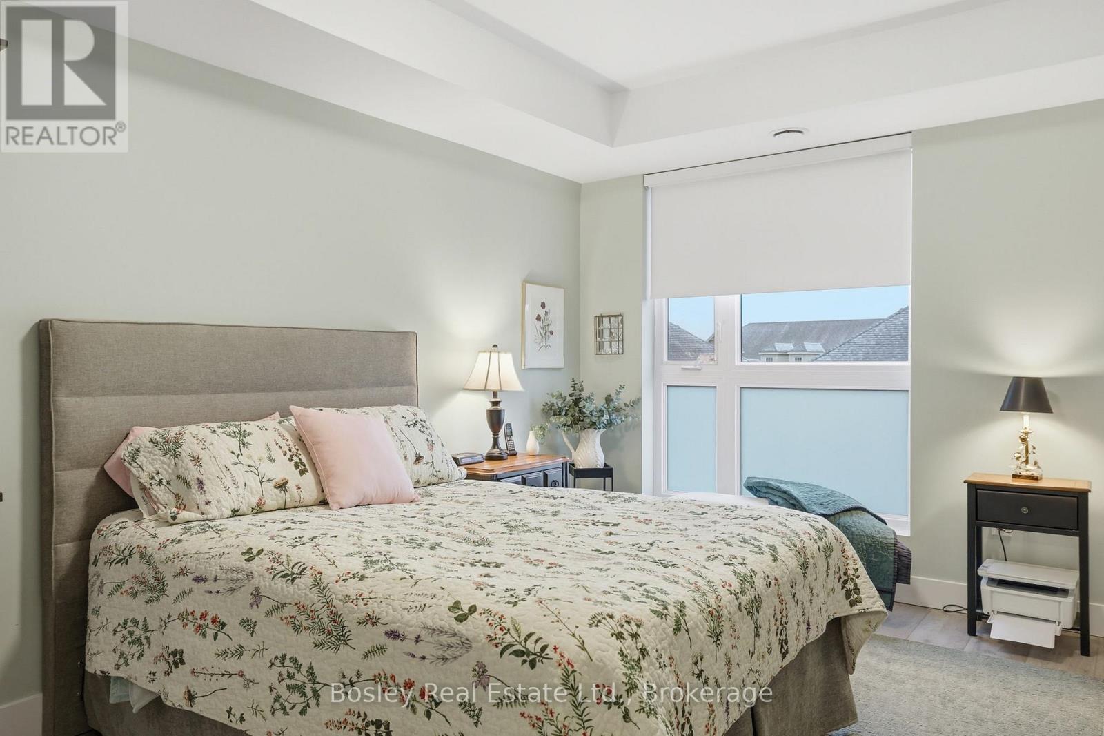 A bedroom with a large bed and a window overlooking a body of water.