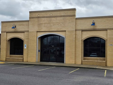 A building with a brick facade and two large arched windows.