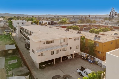 A parking lot with cars and a building in the background.
