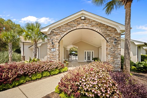 A house with a stone archway entrance and a garden in front.