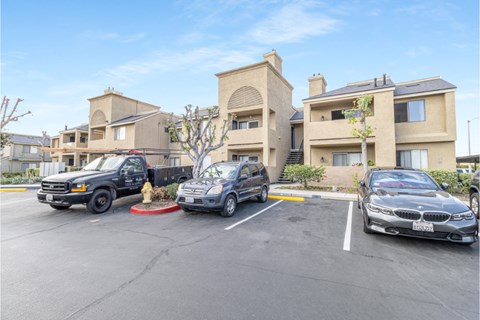 A parking lot with cars and a building in the background.