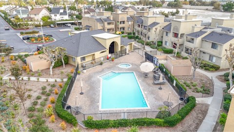 A swimming pool surrounded by a fence and a building in the background.