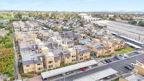 A large apartment complex with a parking lot in front.
