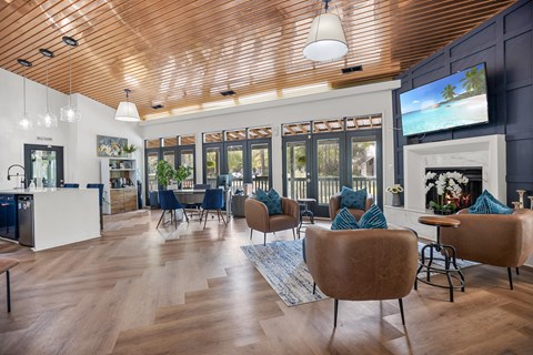 A modern living room with a wooden ceiling and a television on the wall.