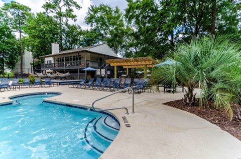 A pool with a slide and a building behind it.
