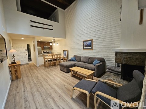 A living room with a grey couch and a fireplace.