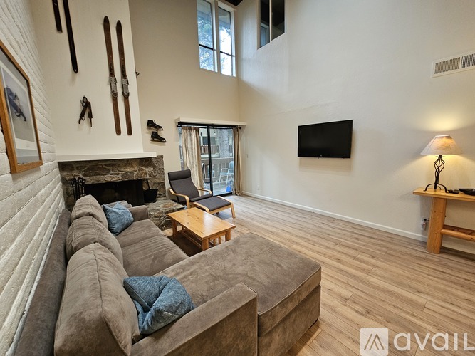 A living room with a grey couch and a fireplace.