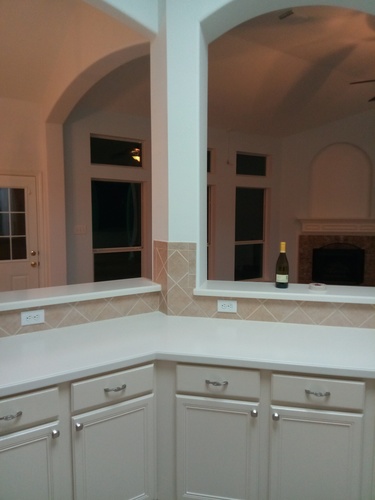 A kitchen with a counter and a wine bottle on it.