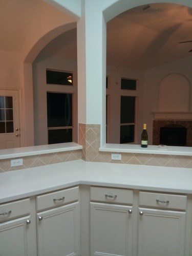 A kitchen with a counter and a wine bottle on it.