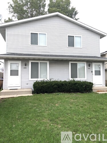 A house with a grey siding and white trim is shown.