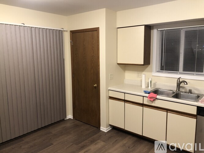 A small kitchen with a sink and a brown door.