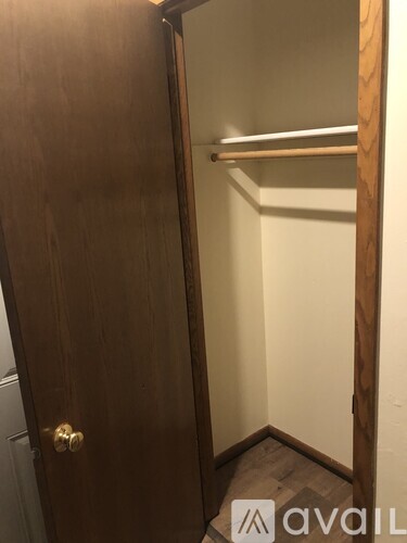 A wooden door with a handle and a small room visible on the other side.