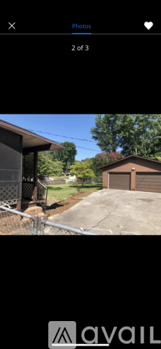 A house with a brown roof and a grey garage door.