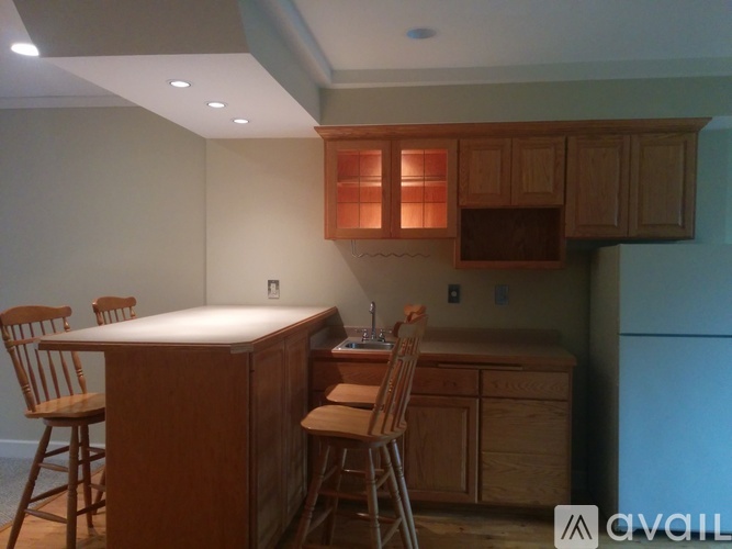 A kitchen with wooden cabinets and a white island.