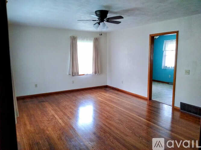A room with wooden floors and a ceiling fan.