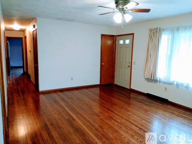 A room with wooden floors and a ceiling fan.