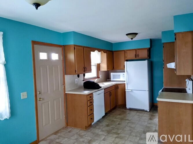 A kitchen with blue walls and wooden cabinets.