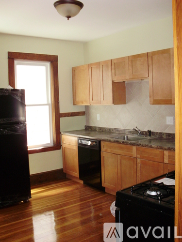 A kitchen with wooden cabinets and a black stove top oven.