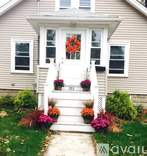 A house with a front porch decorated with flowers and a wreath.
