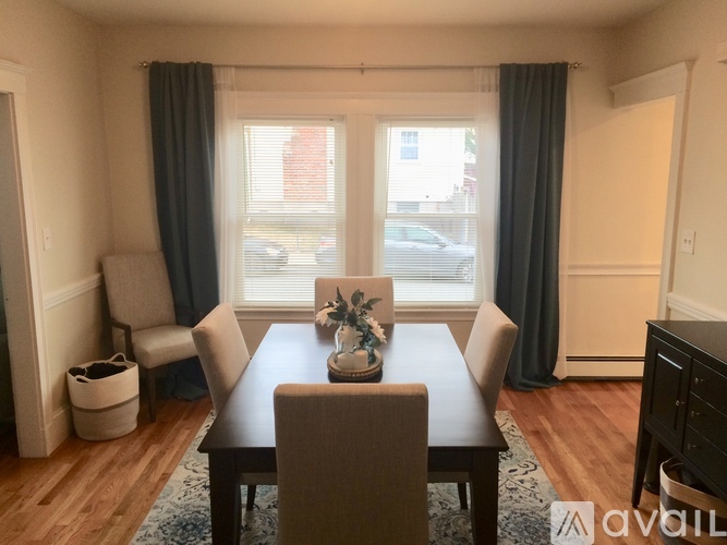 A dining room with a wooden table and chairs.